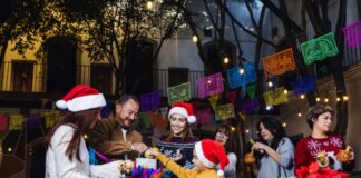 ¿Cuándo comienza y cuándo termina la Navidad? Familia y amigos reunidos en una posada navideña, rompiendo una piñata, con luces cálidas y ambiente de convivencia, paz y alegría.