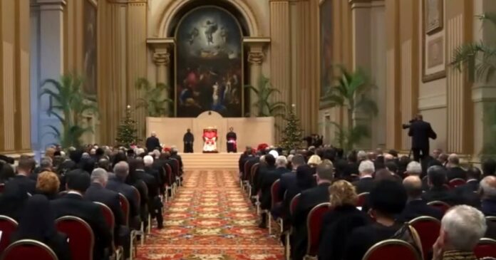 El Papa León XIV sentado en el centro de una gran sala del Vaticano, frente a decenas de diplomáticos y representantes internacionales reunidos en audiencia oficial.