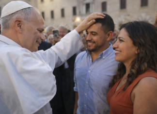 León XIV convoca a los obispos del mundo: algo está pasando con la familia… y la Iglesia lo sabe El Papa León XIV coloca su mano sobre la cabeza de un hombre latino mientras conversa con él y su pareja en una plaza, en un gesto cercano y pastoral.