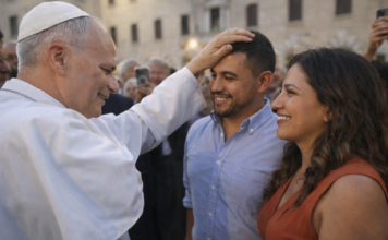 León XIV convoca a los obispos del mundo: algo está pasando con la familia… y la Iglesia lo sabe El Papa León XIV coloca su mano sobre la cabeza de un hombre latino mientras conversa con él y su pareja en una plaza, en un gesto cercano y pastoral.