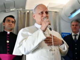 El Papa responde sin confrontar: “No soy un político… basta ya de guerras” El Papa León XIV hablando con un micrófono dentro de un avión, acompañado por miembros de su equipo, durante un encuentro con periodistas.