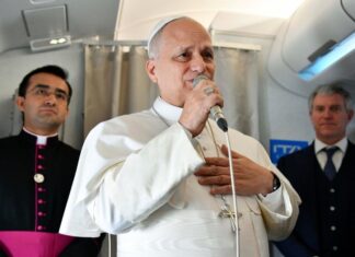 El Papa responde sin confrontar: “No soy un político… basta ya de guerras” El Papa León XIV hablando con un micrófono dentro de un avión, acompañado por miembros de su equipo, durante un encuentro con periodistas.