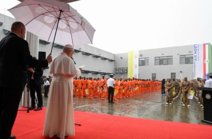 El Papa León XIV visita una cárcel en África y deja un mensaje claro: nadie está fuera del amor de Dios El Papa León XIV, bajo un paraguas, habla ante un grupo de reclusos formados en el patio de una prisión durante una jornada lluviosa.
