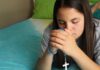 Las jaculatorias: pequeñas oraciones que mantienen el corazón cerca de Dios Manos entrelazadas en oración con un rosario, en un ambiente cálido y contemplativo que representa la espiritualidad cotidiana del católico.