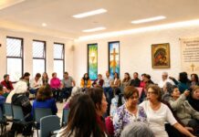 La fe también necesita ser explicada: las encíclicas no deberían quedarse en los escritorios Grupo pastoral católico reunido en un salón parroquial durante una actividad comunitaria y de formación, con símbolos religiosos visibles y ambiente de diálogo.