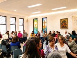 La fe también necesita ser explicada: las encíclicas no deberían quedarse en los escritorios Grupo pastoral católico reunido en un salón parroquial durante una actividad comunitaria y de formación, con símbolos religiosos visibles y ambiente de diálogo.