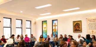 La fe también necesita ser explicada: las encíclicas no deberían quedarse en los escritorios Grupo pastoral católico reunido en un salón parroquial durante una actividad comunitaria y de formación, con símbolos religiosos visibles y ambiente de diálogo.