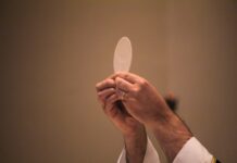 Corpus Christi: el Pan que nos da vida Sacerdote elevando una hostia consagrada durante la celebración de la Eucaristía, en un momento de adoración y recogimiento litúrgico.