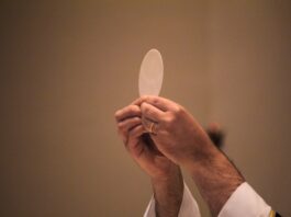 Corpus Christi: el Pan que nos da vida Sacerdote elevando una hostia consagrada durante la celebración de la Eucaristía, en un momento de adoración y recogimiento litúrgico.