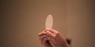 Corpus Christi: el Pan que nos da vida Sacerdote elevando una hostia consagrada durante la celebración de la Eucaristía, en un momento de adoración y recogimiento litúrgico.