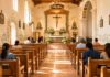 ¿Por qué la Misa ya no ocupa el centro de nuestra vida? Interior de una iglesia católica iluminada con luz natural. Varias personas permanecen sentadas en las bancas mientras observan el altar en un ambiente de silencio, oración y recogimiento.