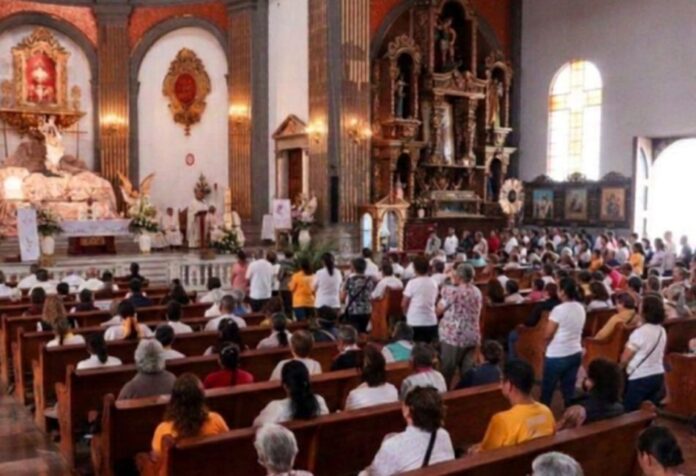 La misa y su lugar central en la Iglesia Fieles reunidos durante la celebración de la Santa Misa en el interior de un templo católico.
