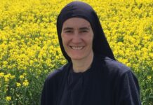Madre María Elena: una mujer que decidió llevar a miles de personas al encuentro con Cristo La Madre María Elena sonríe frente a un amplio campo de flores amarillas, vistiendo su hábito religioso y un crucifijo sobre el pecho