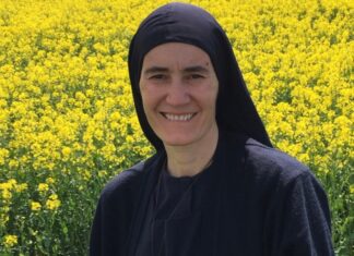 Madre María Elena: una mujer que decidió llevar a miles de personas al encuentro con Cristo La Madre María Elena sonríe frente a un amplio campo de flores amarillas, vistiendo su hábito religioso y un crucifijo sobre el pecho