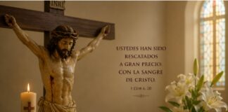 Julio y la Preciosísima Sangre de Cristo: una devoción que nos recuerda hasta dónde llega el amor de Dios Crucifijo sobre un altar con una Biblia abierta, un pequeño cáliz, un cirio encendido y lirios blancos, como representación de la devoción a la Preciosísima Sangre de Cristo durante el mes de julio.
