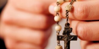 Rezar el Rosario por los difuntos: una oración de esperanza y amor Persona sosteniendo un rosario mientras ora por el eterno descanso de los fieles difuntos.