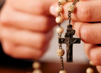 Rezar el Rosario por los difuntos: una oración de esperanza y amor Persona sosteniendo un rosario mientras ora por el eterno descanso de los fieles difuntos.